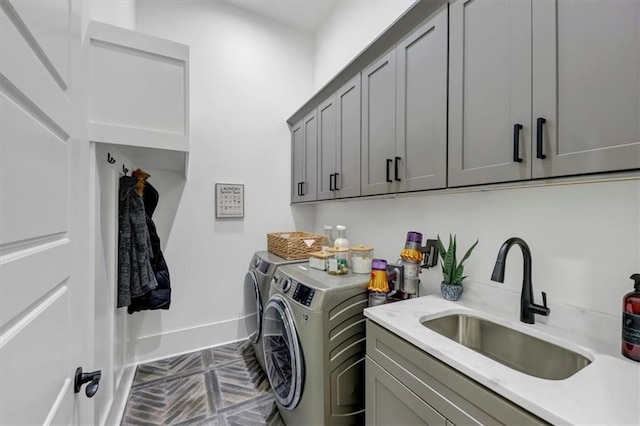 laundry room with cabinets, washer and dryer, and sink