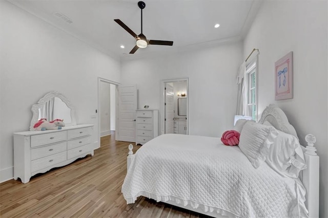 bedroom with light wood-type flooring, ceiling fan, and ensuite bath