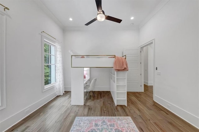 unfurnished bedroom featuring a closet, ceiling fan, light hardwood / wood-style floors, and crown molding