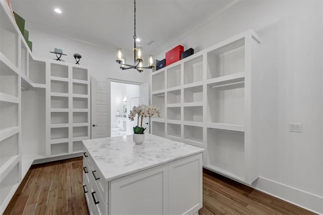 walk in closet with an inviting chandelier and dark hardwood / wood-style flooring