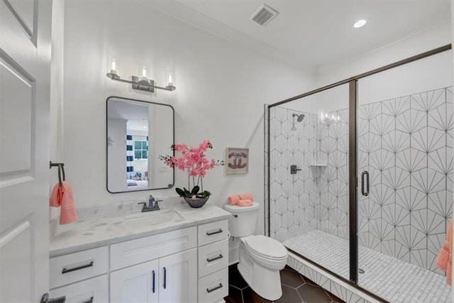 bathroom with vanity, a shower with shower door, tile patterned floors, and toilet