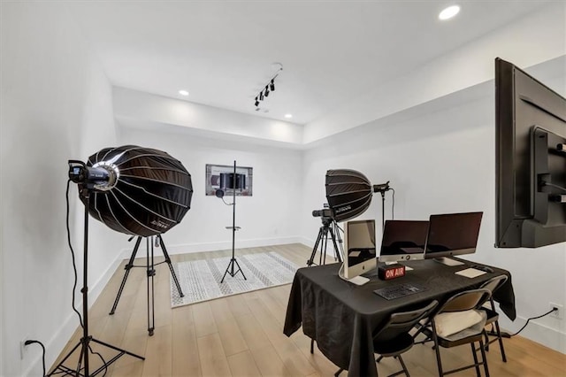 interior space with light wood-type flooring and rail lighting