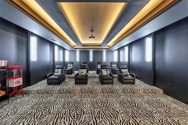 cinema featuring a raised ceiling and carpet flooring