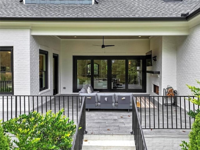 entrance to property with ceiling fan, a patio, and an outdoor living space