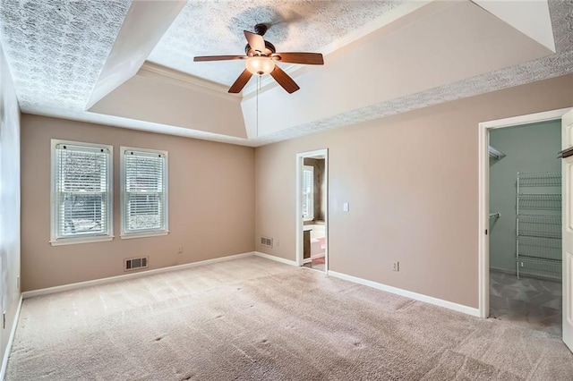 unfurnished bedroom featuring baseboards, a raised ceiling, carpet, and visible vents