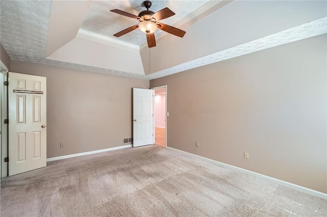 spare room featuring baseboards, carpet flooring, a ceiling fan, and a tray ceiling