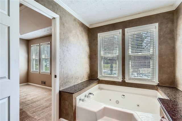 bathroom with crown molding, a jetted tub, a healthy amount of sunlight, and a textured ceiling