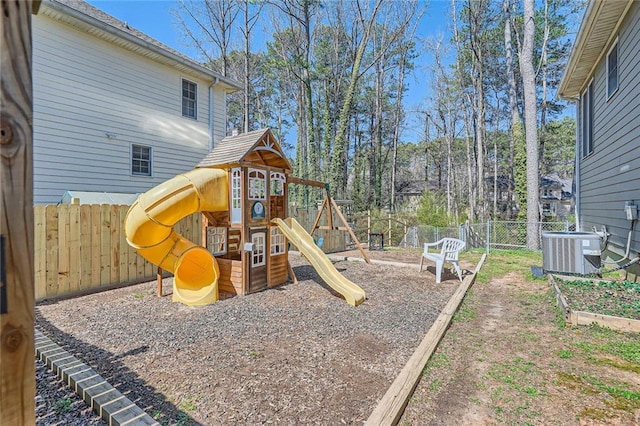 view of playground featuring central air condition unit, a vegetable garden, and fence