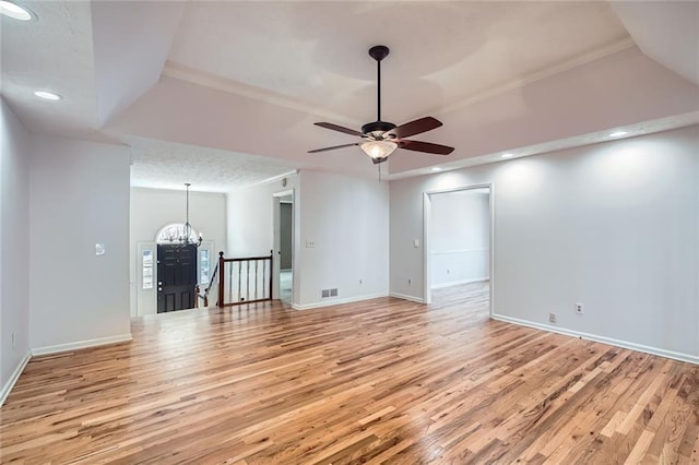 unfurnished living room with baseboards, a textured ceiling, light wood-style flooring, and ceiling fan with notable chandelier