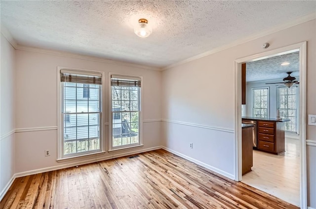 empty room with visible vents, baseboards, light wood-style floors, and a textured ceiling