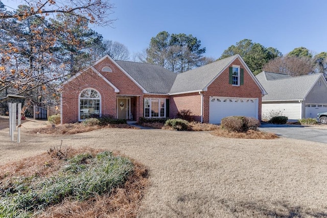 view of front of home with driveway and brick siding