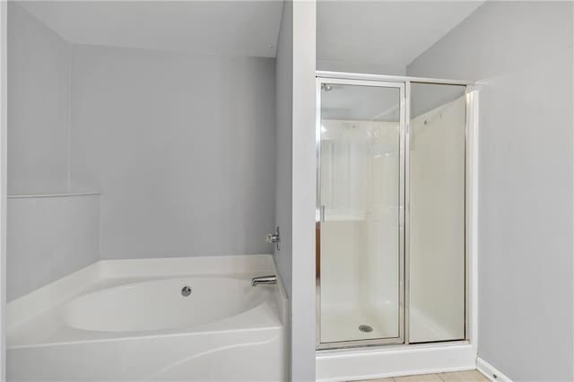 unfurnished bedroom featuring light carpet, baseboards, visible vents, ensuite bath, and vaulted ceiling