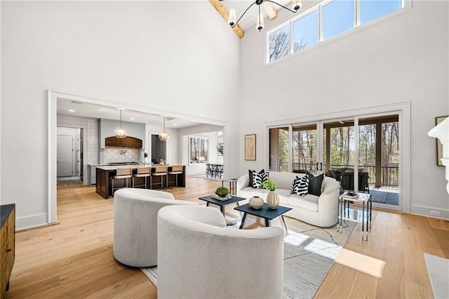 605 Claxton Ln, Milton, GA 30004 - living area featuring light wood finished floors, baseboards, and an inviting chandelier
