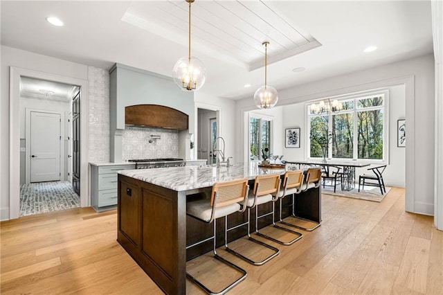 605 Claxton Ln, Milton, GA 30004 - kitchen featuring a wealth of natural light, light wood-style floors, custom range hood, and a raised ceiling