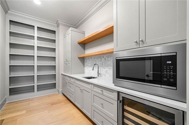 605 Claxton Ln, Milton, GA 30004 - bar featuring stainless steel microwave, ornamental molding, a sink, light wood-style floors, and beverage cooler