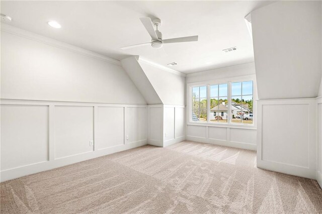 unfurnished bedroom with ceiling fan, light colored carpet, and crown molding