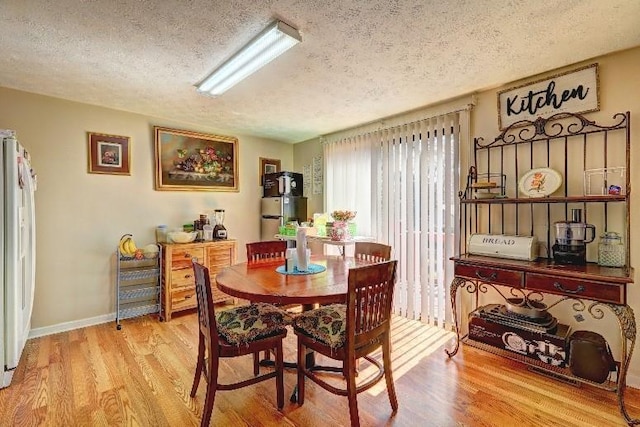 3576 Shrewsbury Ct, Snellville, GA 30039 - dining space featuring light wood-style flooring, baseboards, and a textured ceiling