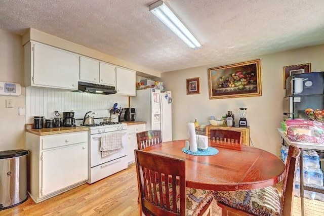 3576 Shrewsbury Ct, Snellville, GA 30039 - kitchen with white cabinetry, a textured ceiling, under cabinet range hood, white appliances, and light wood-style floors