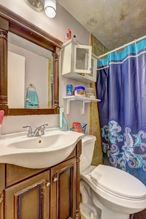 3576 Shrewsbury Ct, Snellville, GA 30039 - full bath with toilet, vanity, a shower with shower curtain, and a textured ceiling