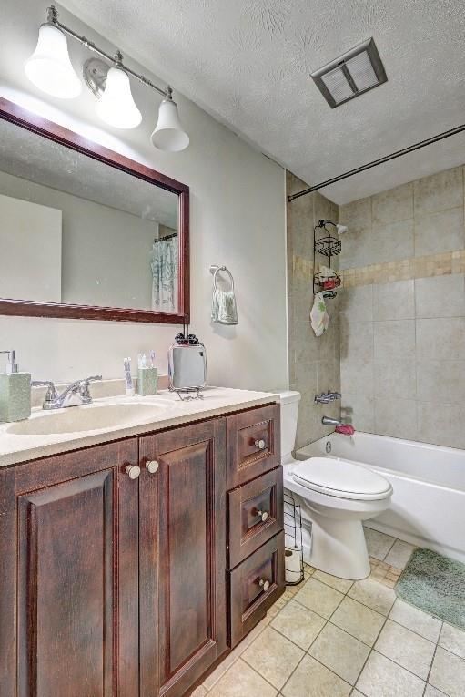 3576 Shrewsbury Ct, Snellville, GA 30039 - full bath with vanity, toilet, a textured ceiling, tile patterned floors, and shower / bath combination with curtain