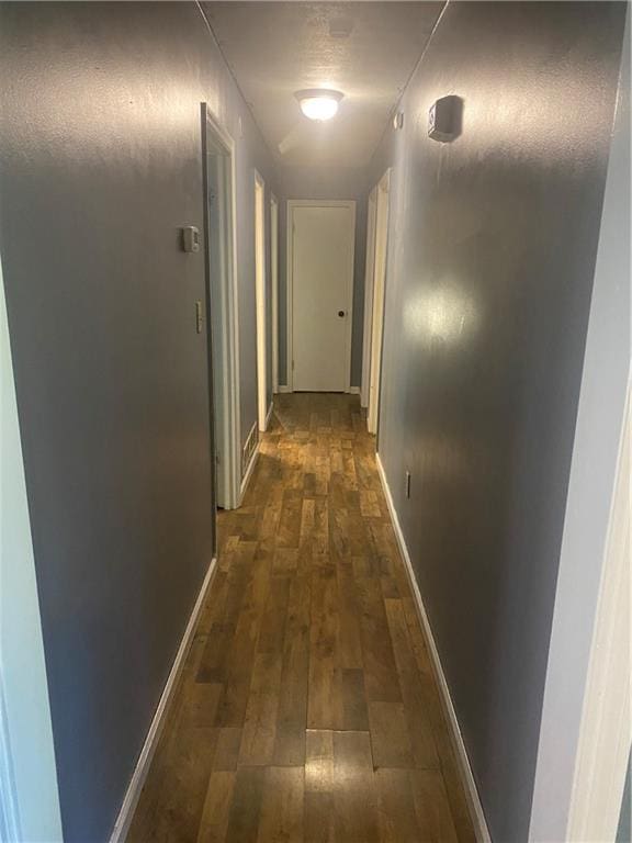 hallway with dark hardwood / wood-style flooring