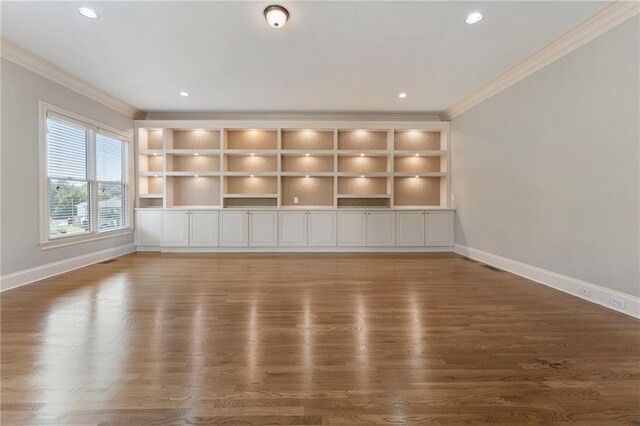 unfurnished living room with crown molding and dark wood-type flooring