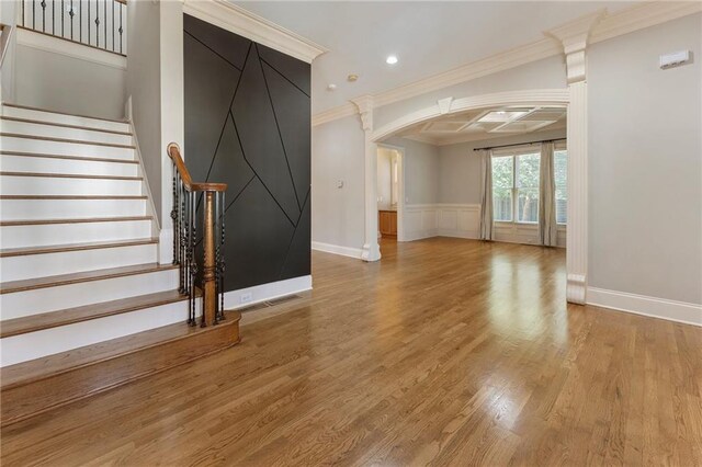 interior space with ornamental molding, coffered ceiling, and light wood-type flooring