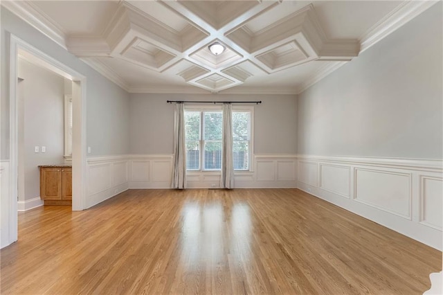 spare room with coffered ceiling, beamed ceiling, light hardwood / wood-style floors, and ornamental molding