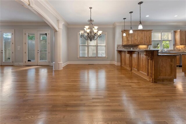 kitchen with tasteful backsplash, hanging light fixtures, dark hardwood / wood-style floors, and a kitchen bar