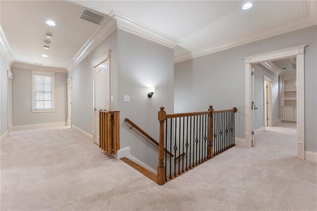 hall with ornamental molding and light carpet