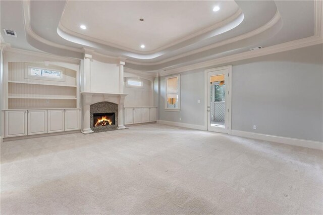 unfurnished living room with a tray ceiling and light colored carpet