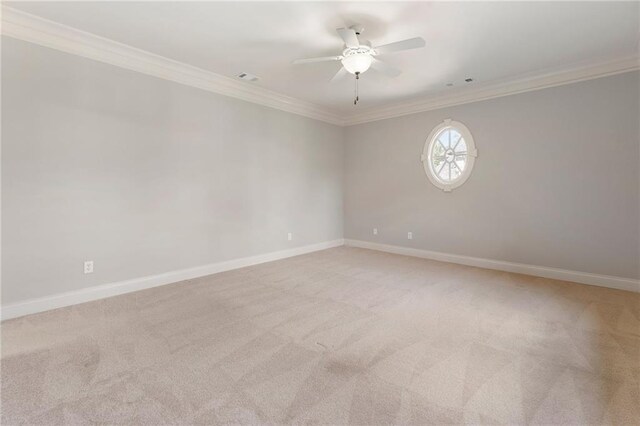 empty room featuring crown molding, light colored carpet, and ceiling fan