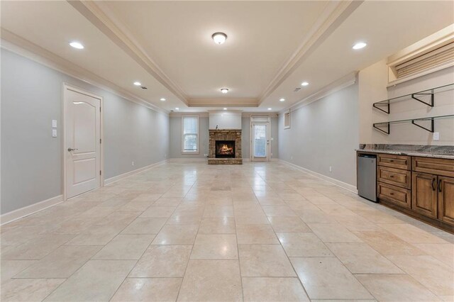 unfurnished living room featuring light tile patterned floors, a fireplace, crown molding, and a raised ceiling