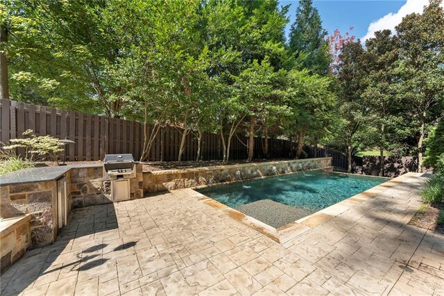 view of pool featuring area for grilling, grilling area, a patio, and pool water feature