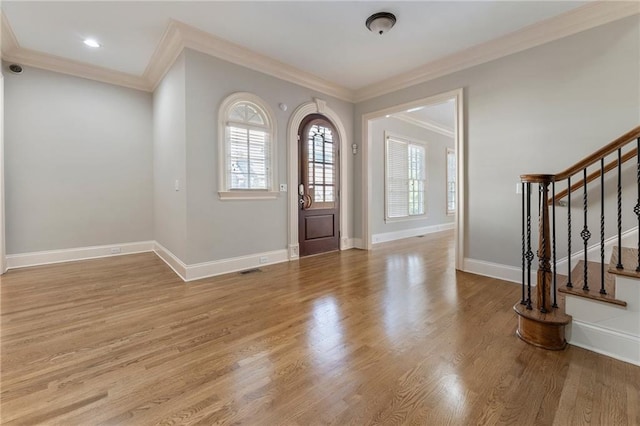 entryway with crown molding and light hardwood / wood-style floors