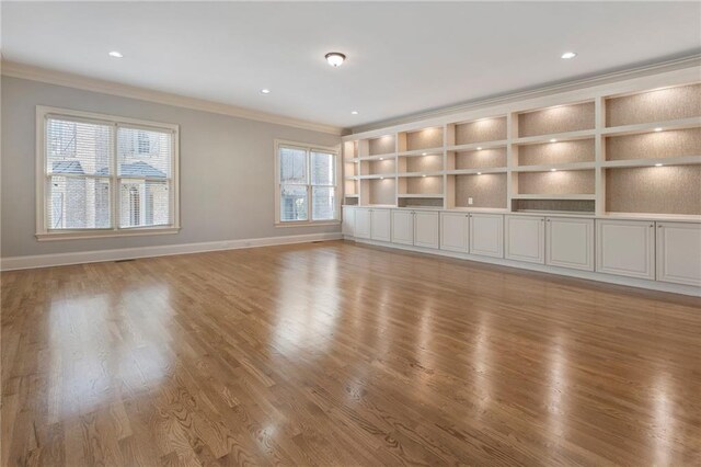 unfurnished living room with hardwood / wood-style flooring and ornamental molding