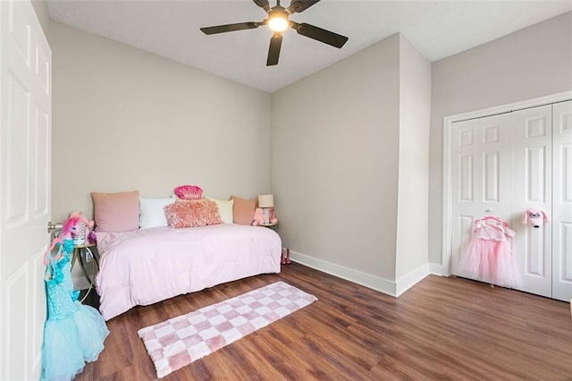 bedroom with wood finished floors, ceiling fan, a closet, and baseboards