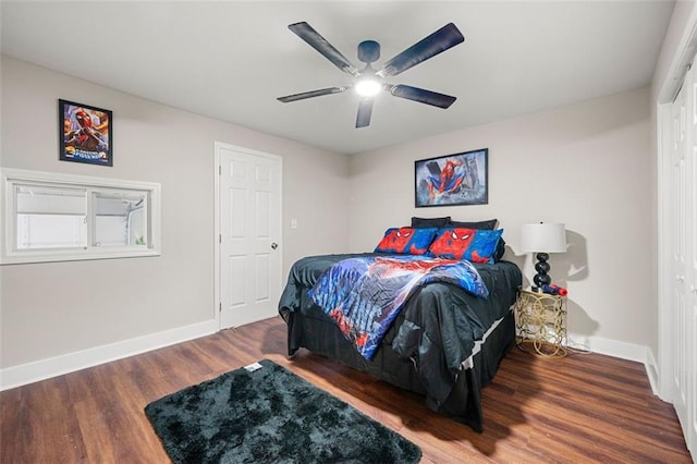 bedroom with ceiling fan, wood finished floors, and baseboards