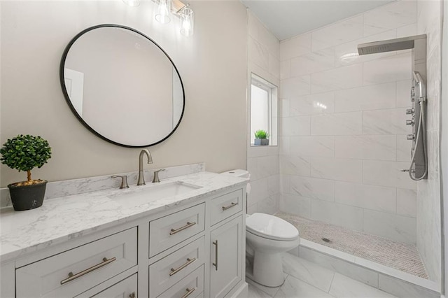 full bathroom with toilet, marble finish floor, tiled shower, and vanity