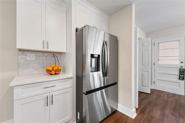 kitchen featuring dark wood-style flooring, tasteful backsplash, stainless steel refrigerator with ice dispenser, baseboards, and white cabinets