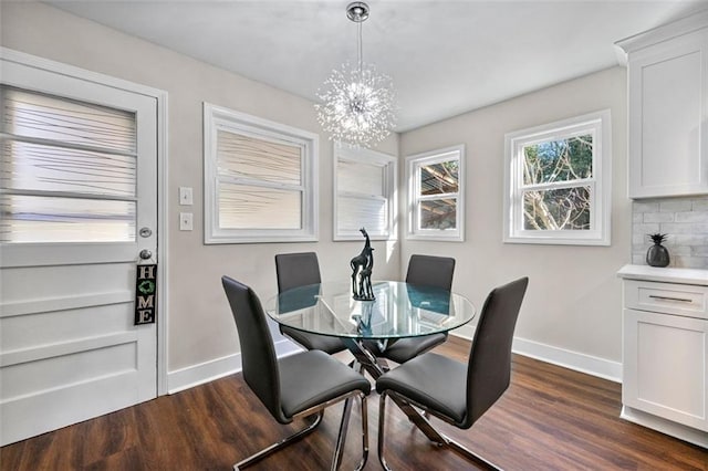 dining space featuring baseboards, a notable chandelier, and dark wood-style flooring
