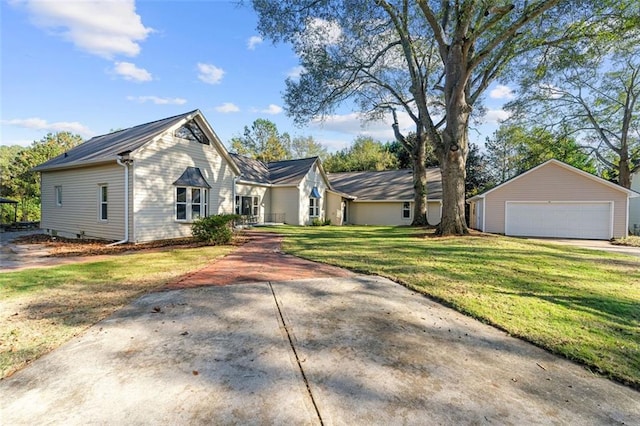 view of front of home with an outbuilding, a detached garage, and a front yard