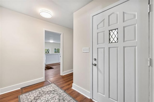 foyer entrance featuring dark wood-style floors and baseboards