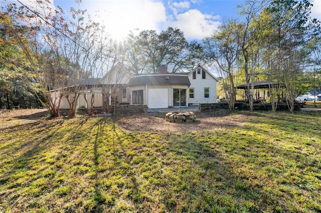 rear view of property with a lawn, a gazebo, and a chimney