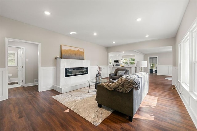 living room with wainscoting, wood finished floors, and a fireplace