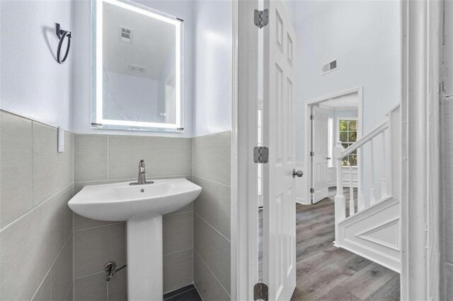 bathroom with tile walls and hardwood / wood-style floors