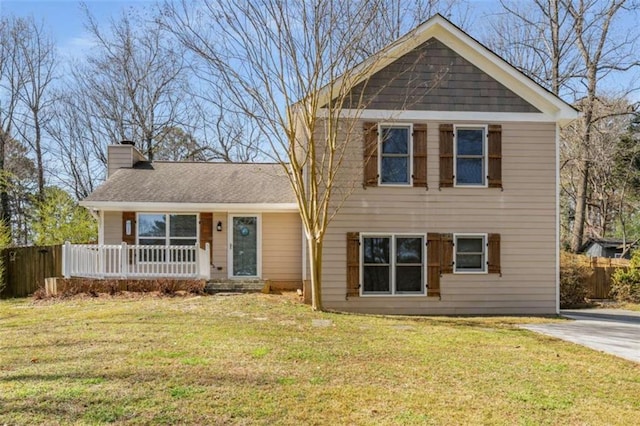 tri-level home featuring a front lawn, a chimney, a porch, and fence