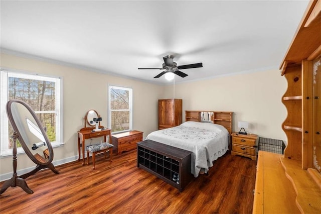 bedroom featuring a ceiling fan, crown molding, baseboards, and wood finished floors