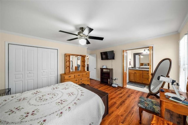 bedroom with baseboards, ceiling fan, ornamental molding, wood finished floors, and a closet