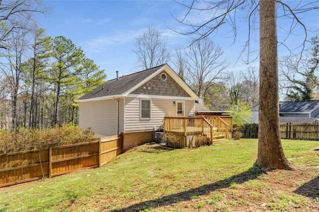 rear view of house with a yard, fence, and a wooden deck